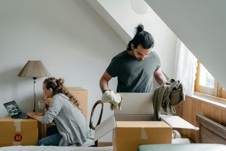 A couple is unpacking after moving in in the concept of things to consider for moving to Hackney.