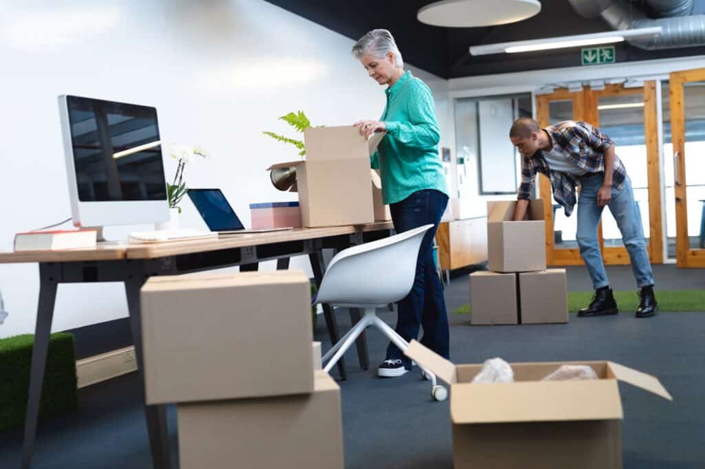 Male and female employees unpacking in their new office