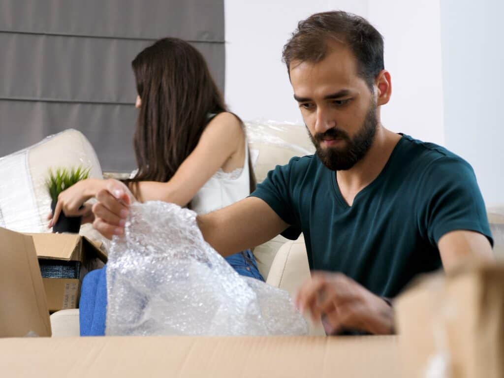 A Young Couple Busy Packing The Night Before The Moving Day